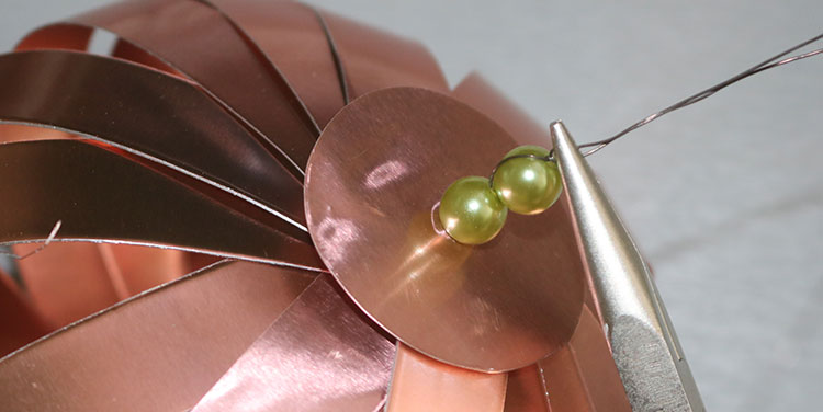 Mit der zweiten Perle wird die erste fixiert. Anleitung Kürbis aus Metallfolie Tischdeko