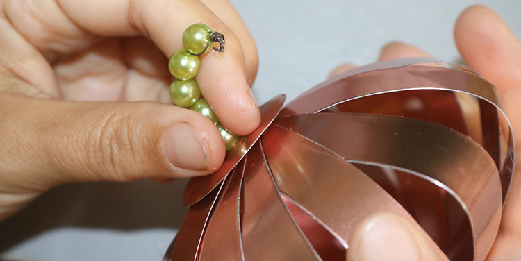 Mit der zweiten Perle wird die erste fixiert. Anleitung Kürbis aus Metallfolie Tischdeko