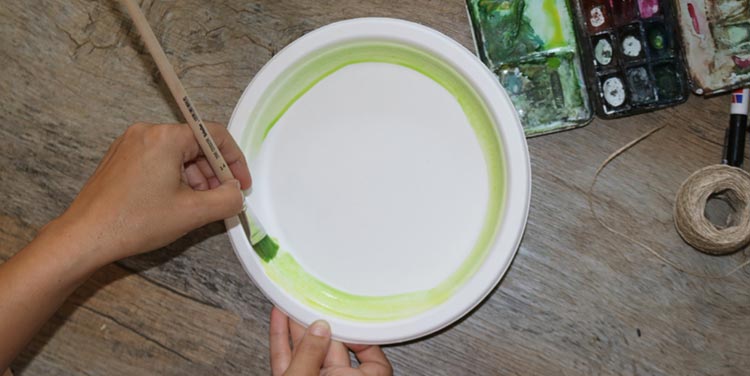 Pappteller mit hellgrüner Farbe bemalen