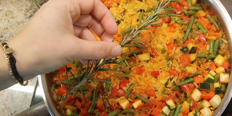 Paella mit Rosmarin bedecken