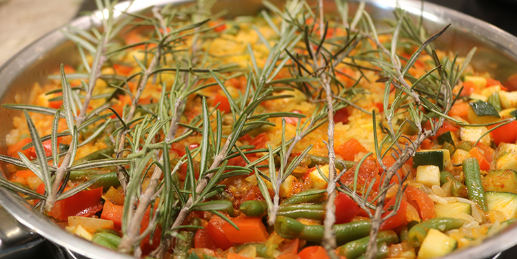 Paella mit Rosmarin bedecken