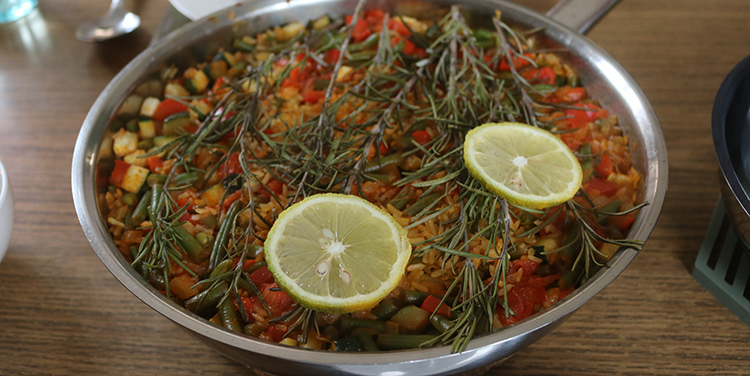 Paella mit Zitronenscheiben garnieren.