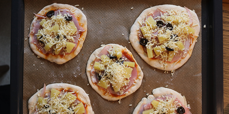 Pizza mit Käse bestreuen.