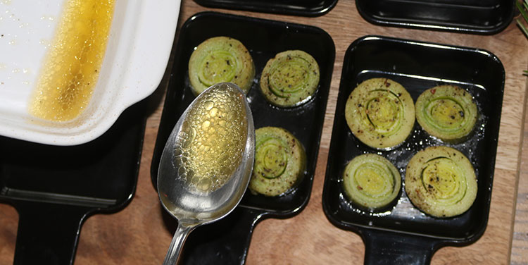 Lauch auf die Pfännchen verteilen und mit dem Garsaft beträufeln. Lauch Käse Raclette Pfännchen