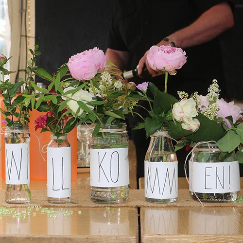 einfache Tischdeko mit Gläsern und Blumen